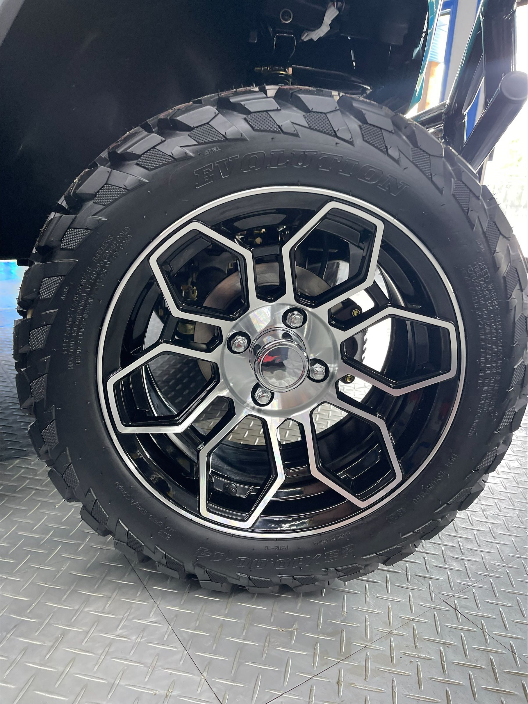 Black and silver rim with a rugged tire, mounted on a vehicle.