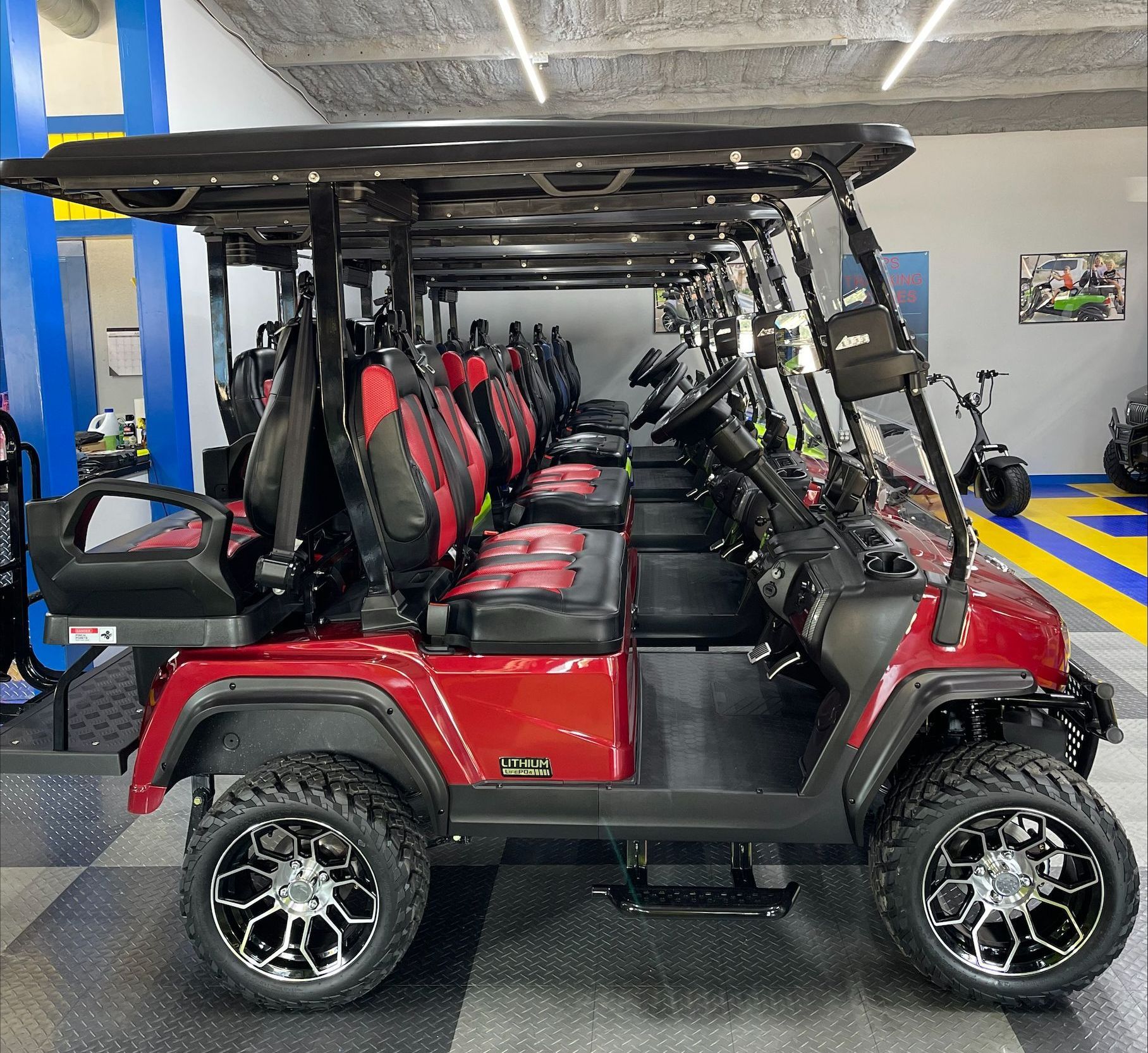 A row of golf carts are lined up in a showroom.