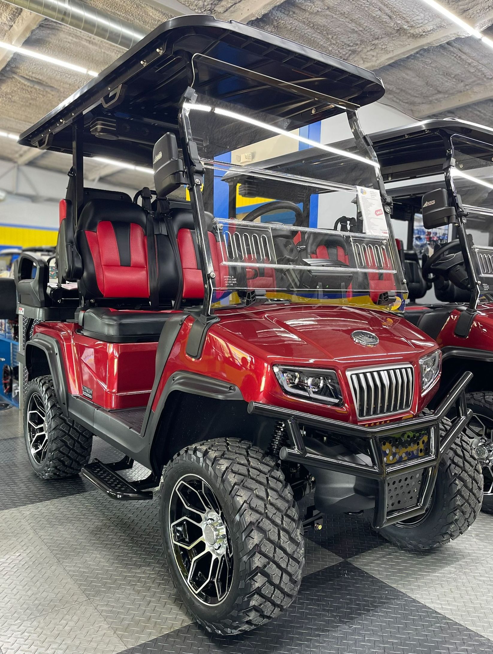 A red golf cart is parked in a showroom.