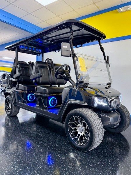 A black golf cart is parked in a garage.