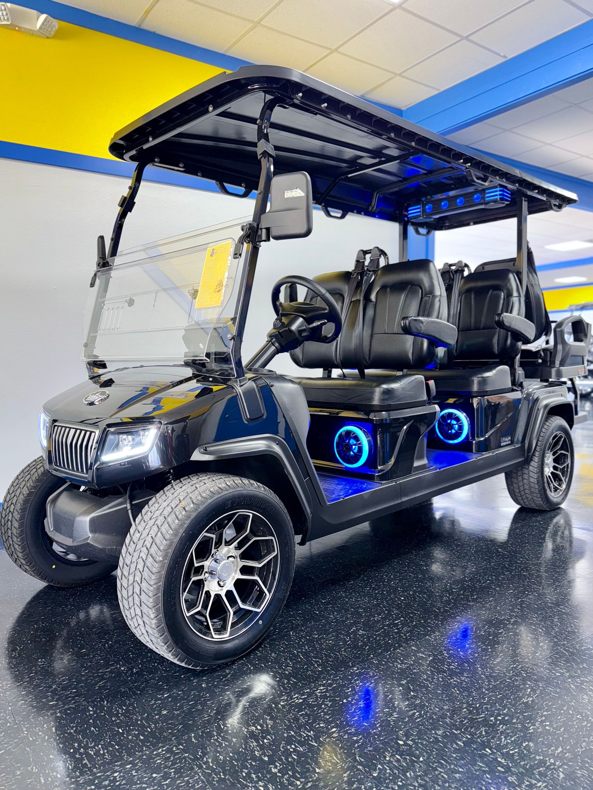A black golf cart is parked in a showroom.