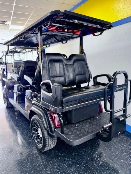 A black golf cart is parked in a garage