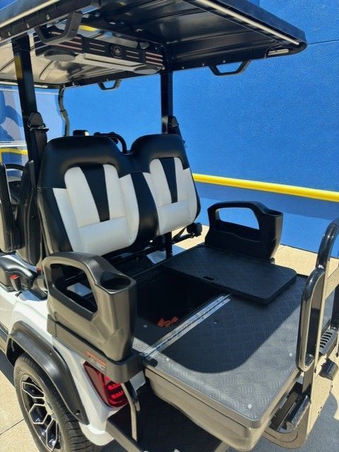 A white golf cart with black and white seats