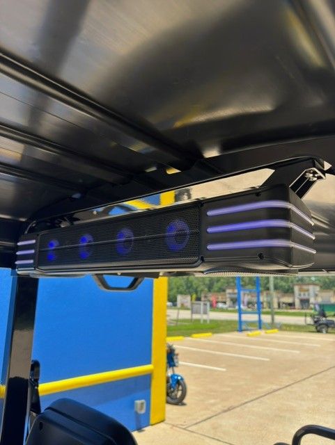 A speaker mounted to the roof of a golf cart