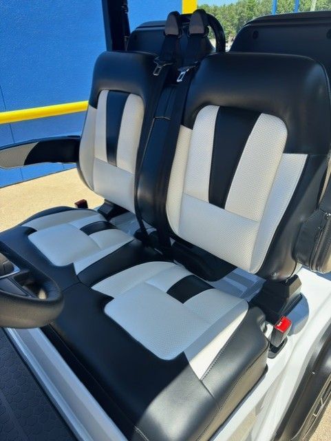 The seats of a golf cart are black and white