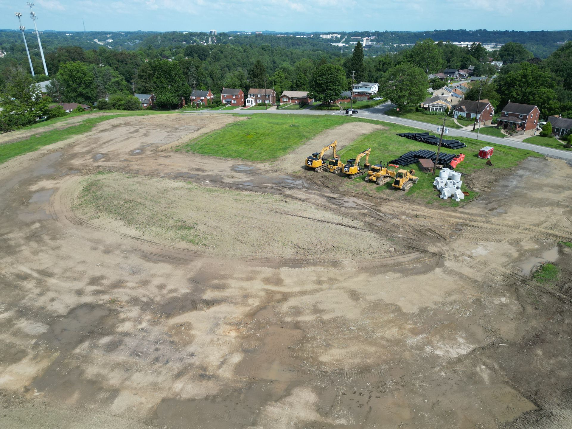An aerial view of a dirt field with tractors in it.