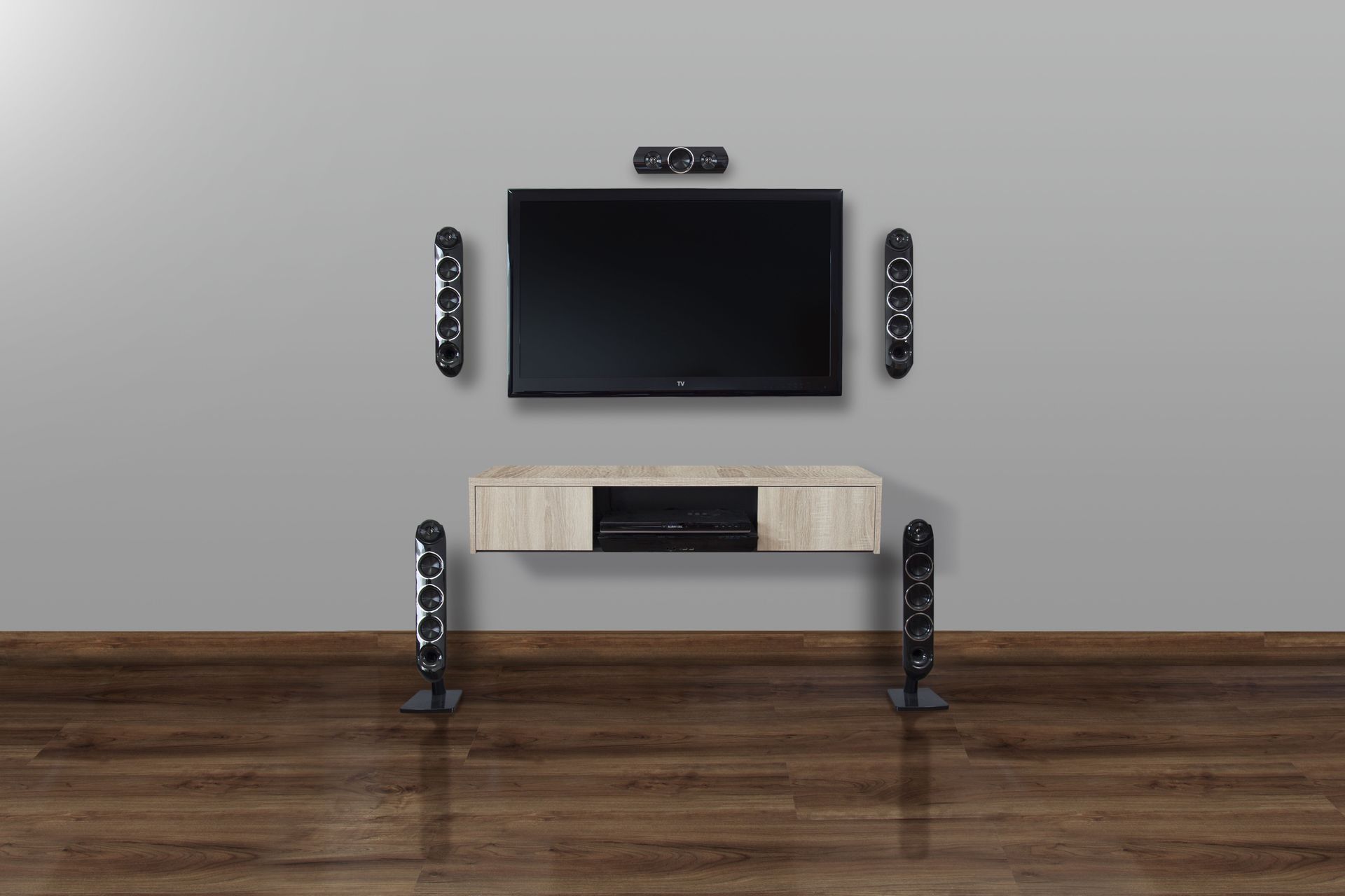 Wall-mounted TV, sound system, and console on a gray wall, set against a wood floor.