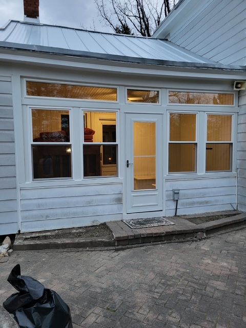 A white house with a metal roof and many windows