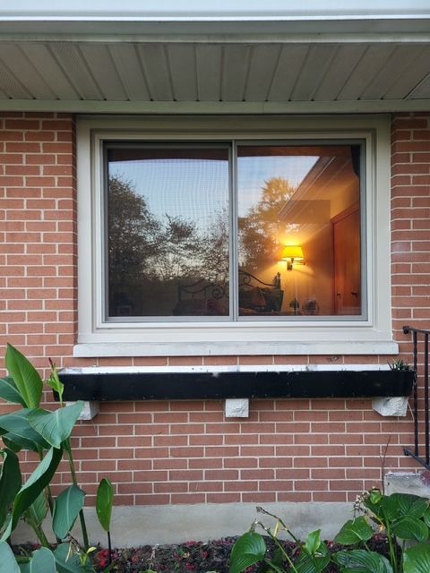 A large window in a room with a view of a house.