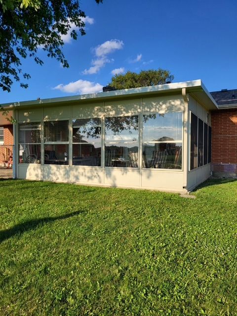 A house with a screened in porch and lots of windows