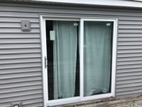 There is a sliding glass door on the side of a house.