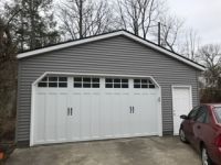 A garage with a car parked in front of it.
