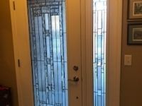 A door with a stained glass window in a hallway.