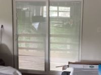 A bedroom with a sliding glass door leading to a deck.