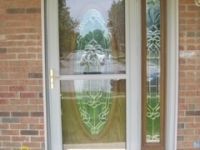 A white door with a stained glass window on a brick building.