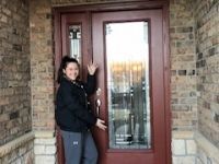 A woman is standing in front of a red door.