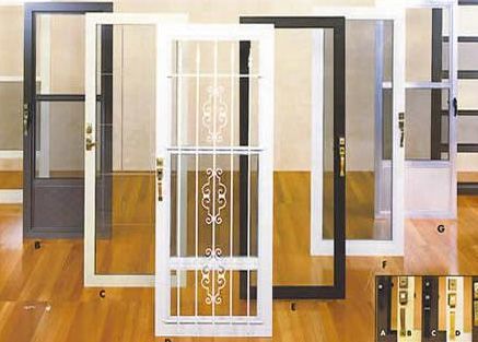 A bunch of different types of screen doors on a wooden floor