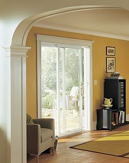 A living room with yellow walls and a sliding glass door.