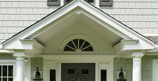 A white house with a porch and a black door.