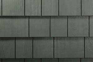 A close up of a gray shingle siding on a house.