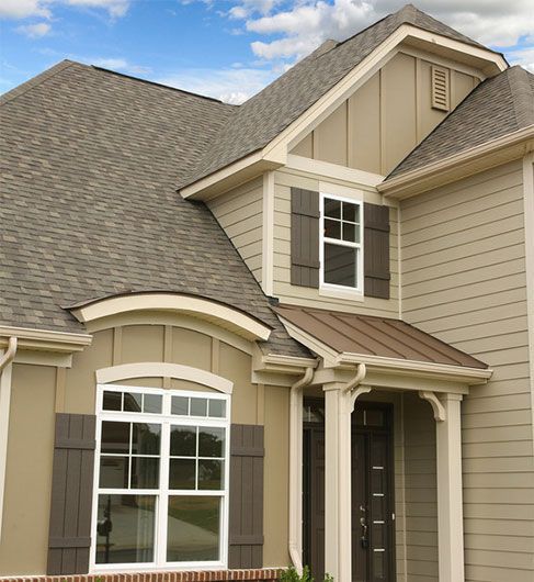 A house with a gray roof and brown shutters