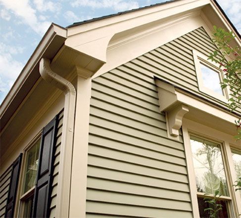 A house with a green siding and black shutters