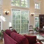 A living room with a couch , chairs , and sliding glass doors.