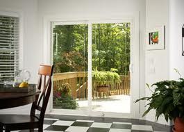 A dining room with a table and chairs and a sliding glass door leading to a deck.