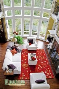 An aerial view of a living room with a couch , chairs , coffee table and rug.