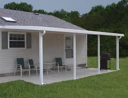 A small white house with a porch and chairs.