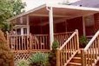 A house with a screened in porch and stairs leading up to it.