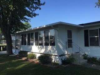 A white house with a screened in porch and stairs