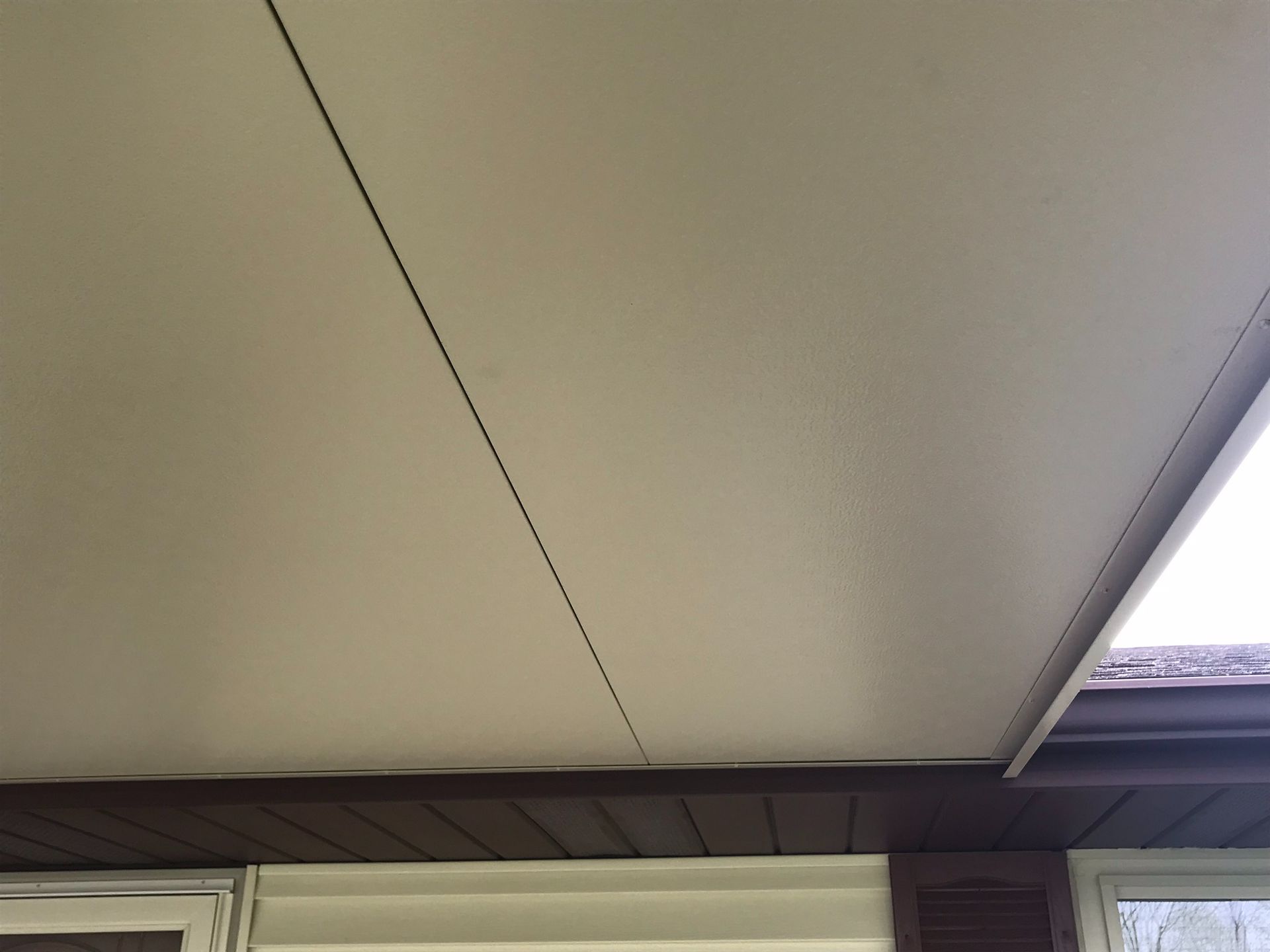 A close up of the ceiling of a house with a window.