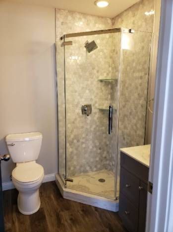 A bathroom with a toilet and a walk in shower.
