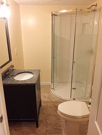 A bathroom with a toilet , sink and shower stall.