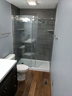A bathroom with a toilet , sink , and walk in shower.
