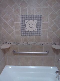 A bathroom with a bathtub and a hand rail.