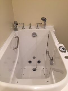 A walk in tub is sitting in a bathroom next to a shower.