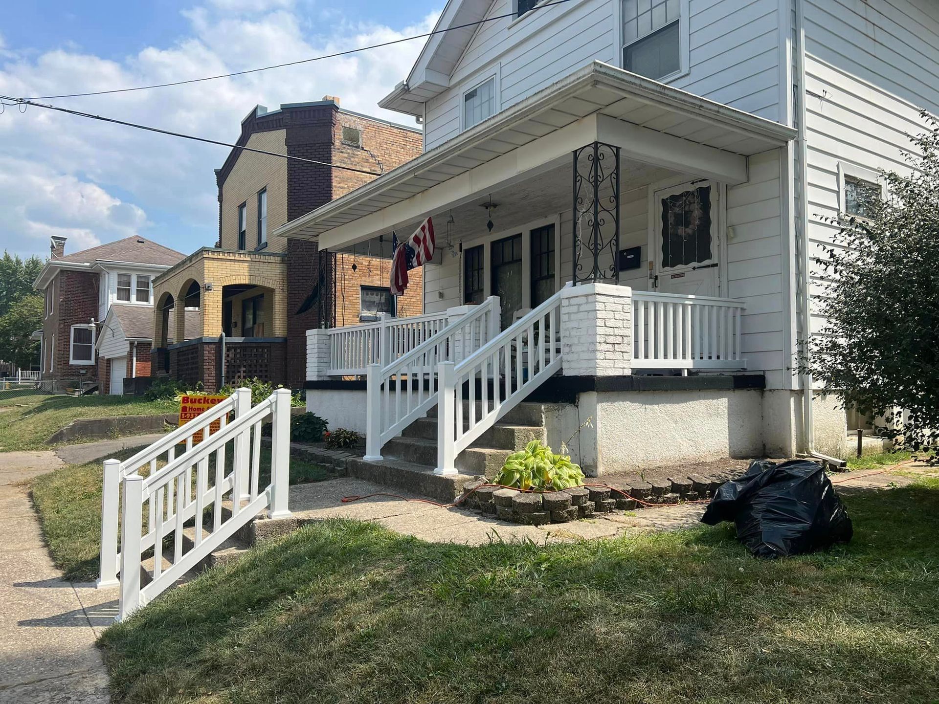 A white house with stairs leading up to the front porch.
