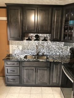 A kitchen with a sink , cabinets , drawers and a stove.