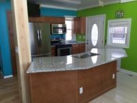 A kitchen with a large island in the middle and green walls.