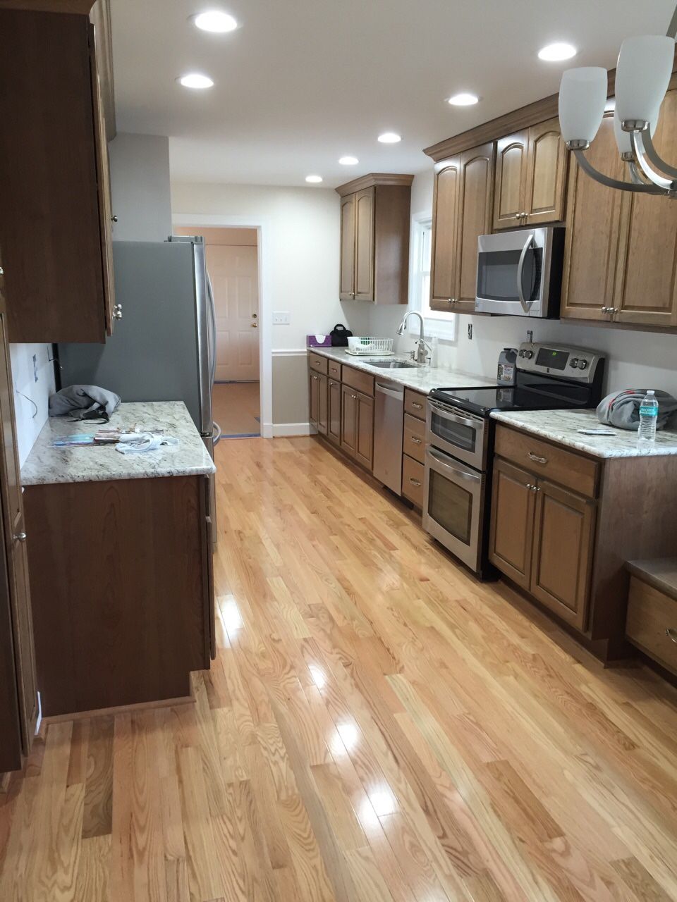 A kitchen with hardwood floors and stainless steel appliances.