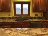 A kitchen with a sink , dishwasher , and window.