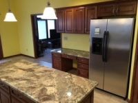 A kitchen with stainless steel appliances and granite counter tops.