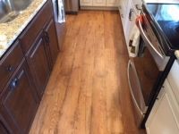 A kitchen with hardwood floors and stainless steel appliances.
