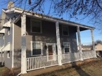 A large house with a porch and a white railing.
