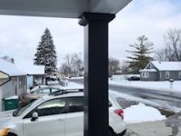 A car is parked on the side of the road in the snow.