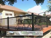 A deck with a fence around it and a table and chairs on it.