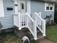 A blue house with a white porch and stairs.