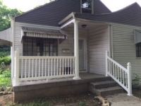 A small white house with a porch and stairs.